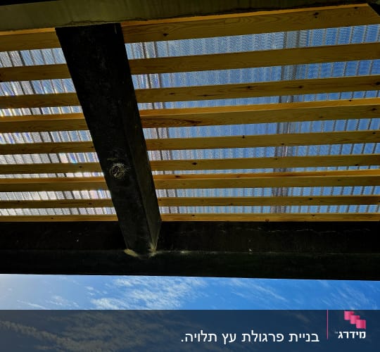 קורות עץ עם כיסוי פלסטיק שקוף בגינה